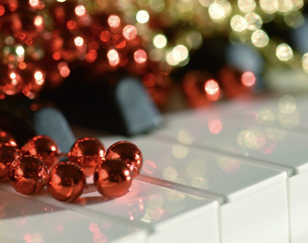 Sparkly Holiday Piano decorated with glimmering, shimmering colorful shiny red and gold beaded bokeh
